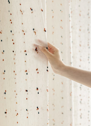 a person is holding the curtain with their hand