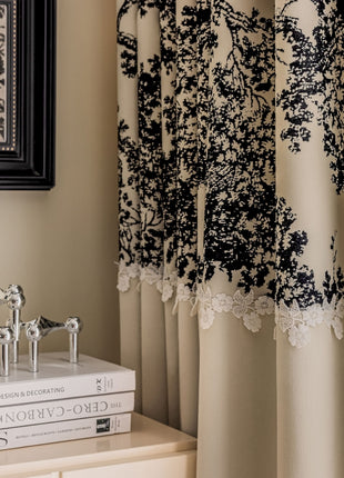 a black and white lace curtain hanging on the side of a window