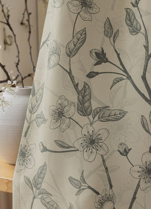 a white vase sitting next to a window covered in a curtain