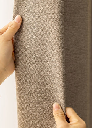 a person holding a curtain with their hand