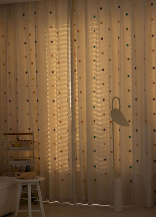a living room with a white couch and curtains