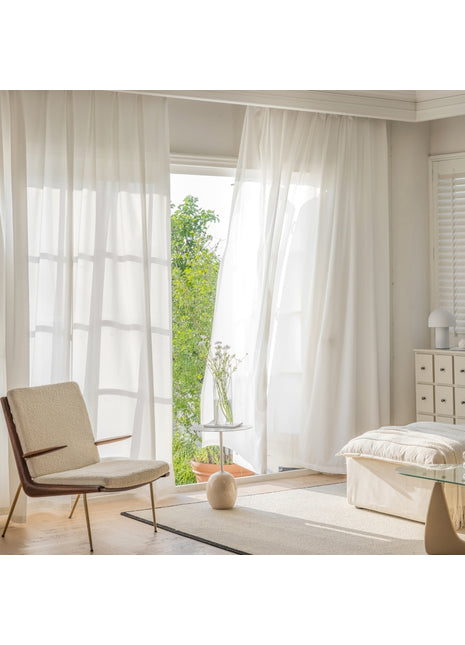 a bedroom with a bed, chair and window