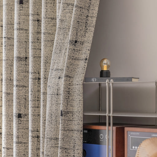 a room with a shelf and a window with a curtain