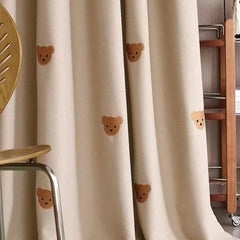 Rideau enfant en coton beige à petits oursons brodés dans une chambre lumineuse