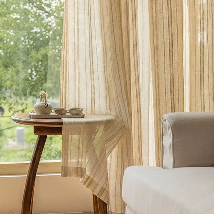 a small table with a cup on it next to a window