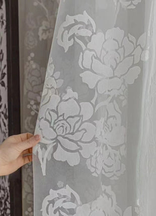 a person holding a curtain with a flower pattern on it