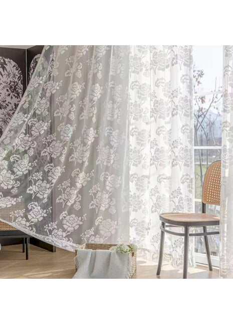 a living room with a chair and a curtain
