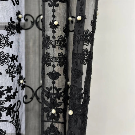 a curtain with black lace and pearls on it