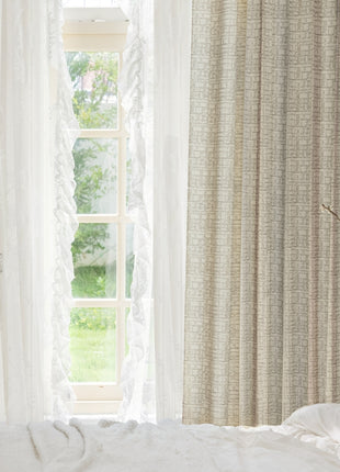 a bed with a white comforter and a window