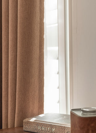 a book sitting on top of a wooden table next to a window