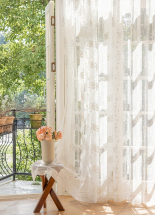 a vase of flowers sitting on a table in front of a window