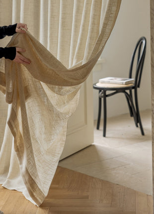 a woman holding a piece of cloth in front of a window