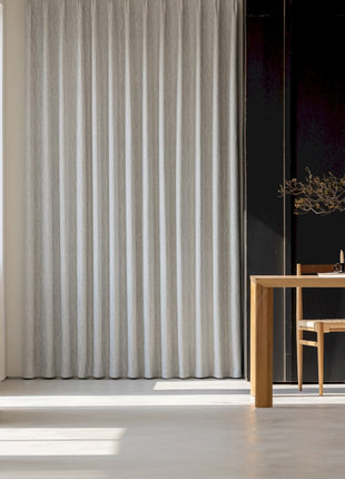 a room with a table, chair and a vase