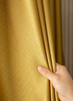 a hand holding a curtain with a gold color