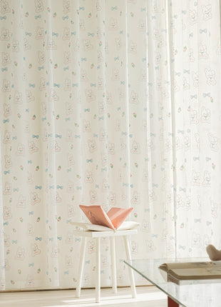 a teddy bear sitting on a stool next to a window