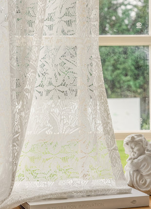 a window with a curtain and a vase on a table