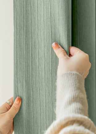 a woman is holding a curtain with her hand