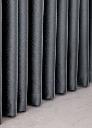 a row of black curtains sitting on top of a floor