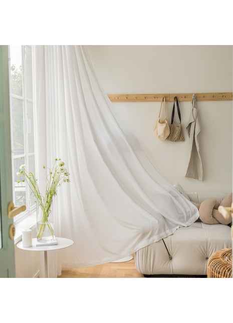 a living room with a white couch and a white curtain