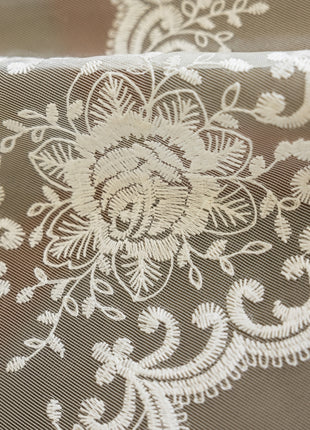 a close up of a white lace on a piece of cloth