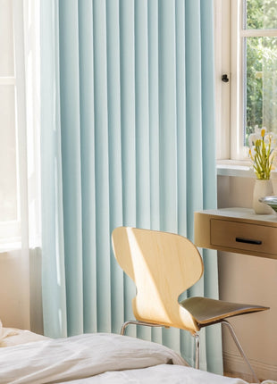 a bedroom with a bed, desk, chair and a window