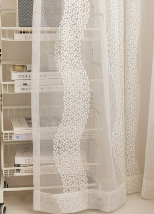 a room with a white curtain and a white chair