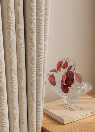 a glass vase with red flowers on top of a wooden table