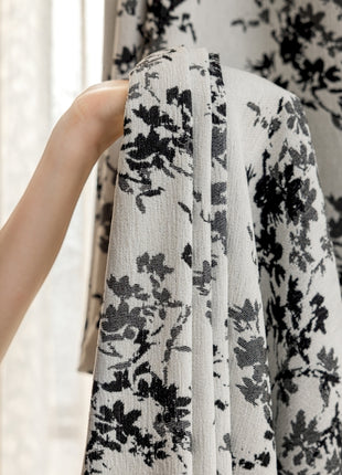 a person is holding up a black and white dress