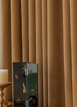 a candle is sitting on a table next to a curtain