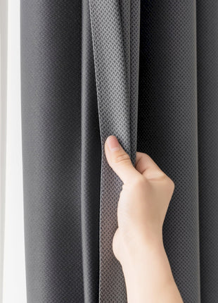 a hand is pulling the curtain off of a window