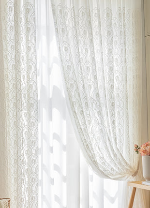 a window with a white curtain and a basket of flowers