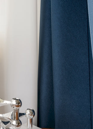 a close up of a faucet with a curtain in the background