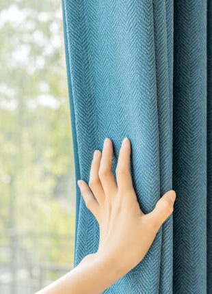 a person's hand on the curtain of a window