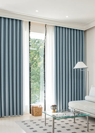 a living room with a white couch and blue curtains