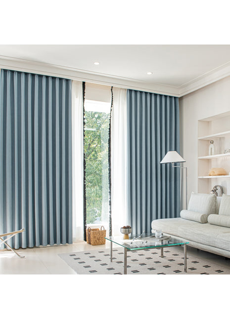 a living room with a white couch and blue curtains