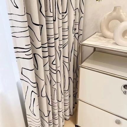 a white dresser sitting next to a window covered in curtains