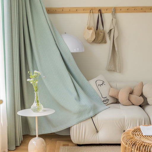 a living room with a white couch and a green curtain