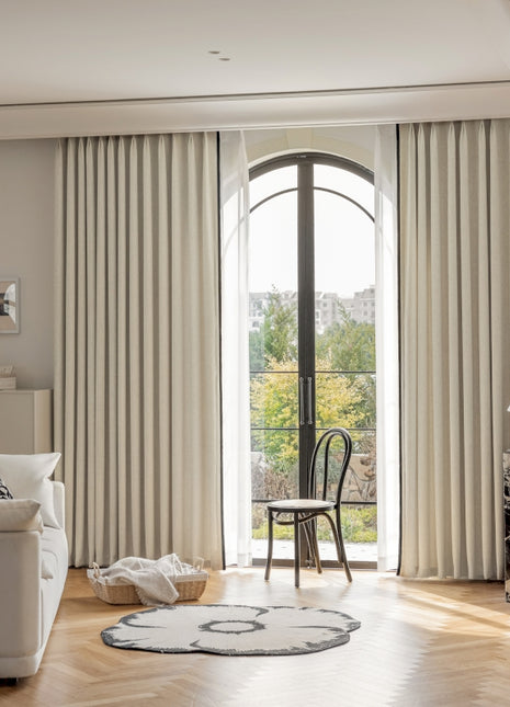 a living room with a white couch a chair and a window