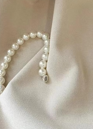 a close up of a white fabric with pearls