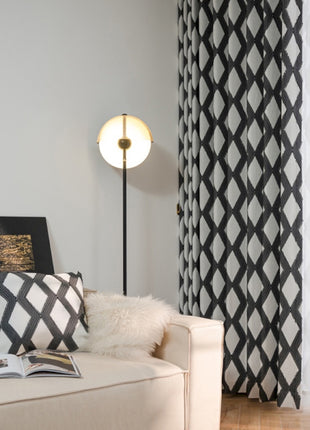 a living room with a white couch and black and white curtains