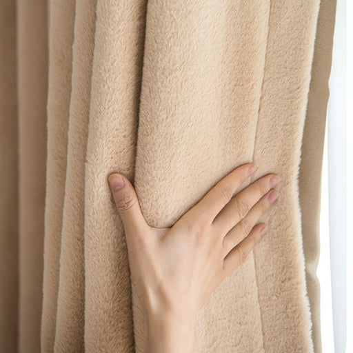 a person's hand on the curtain of a window