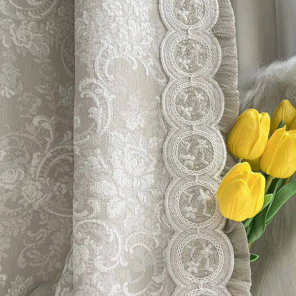 a bouquet of yellow tulips sitting on top of a curtain