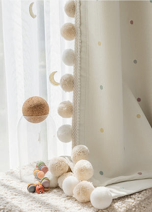 a window with a curtain and some balls on the window sill
