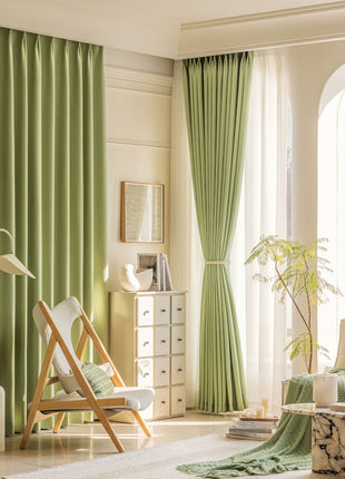 a living room filled with furniture and green curtains