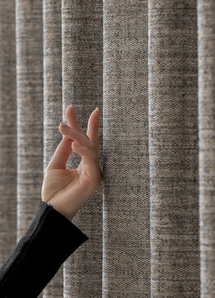 a person's hand reaching up from behind a curtain