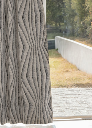 a window with a curtain that has wavy lines on it