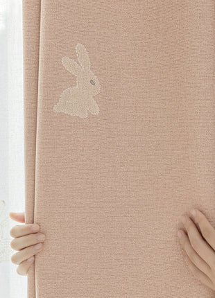 a person is holding a curtain with a rabbit sticker on it