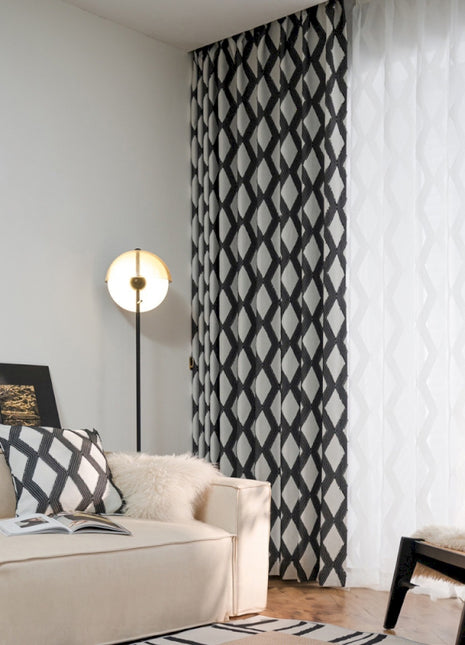 a living room with a white couch and black and white curtains
