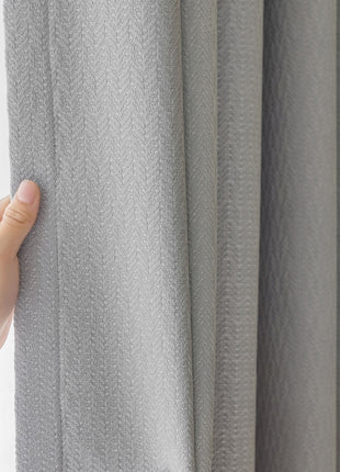 a hand is holding the curtain in front of a window