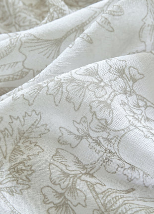 a close up of a white fabric with a flower pattern